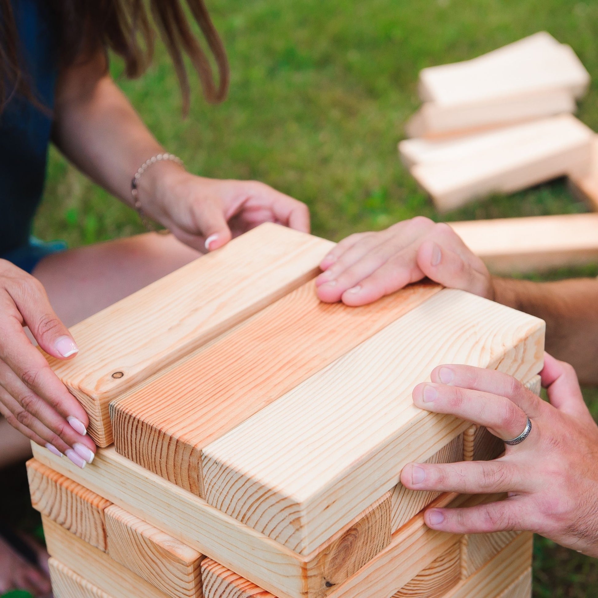 people stack wooden tumble block party rental game in Louisville Kentucky