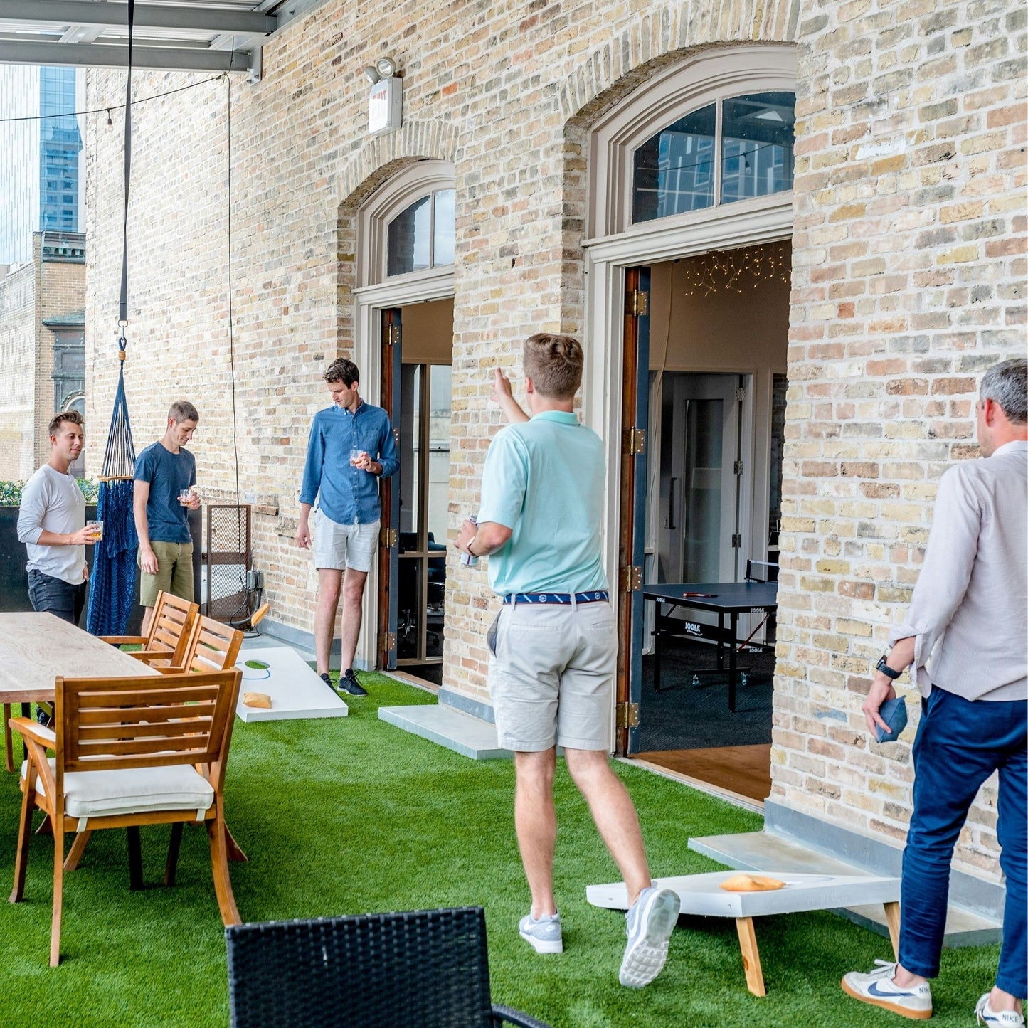 Lifesize cornhole game rental played outdoors on patio